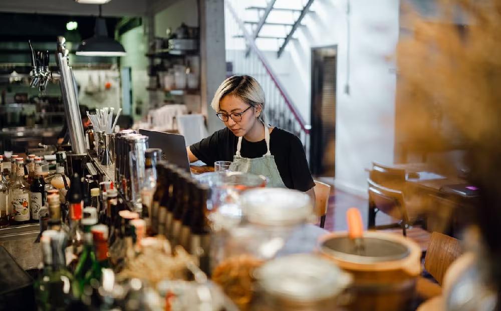 Young concentrating female bartender working at counter